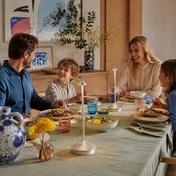 Twee kleine lampjes zorgen voor een evenwichtig warm licht op een lange tafel.