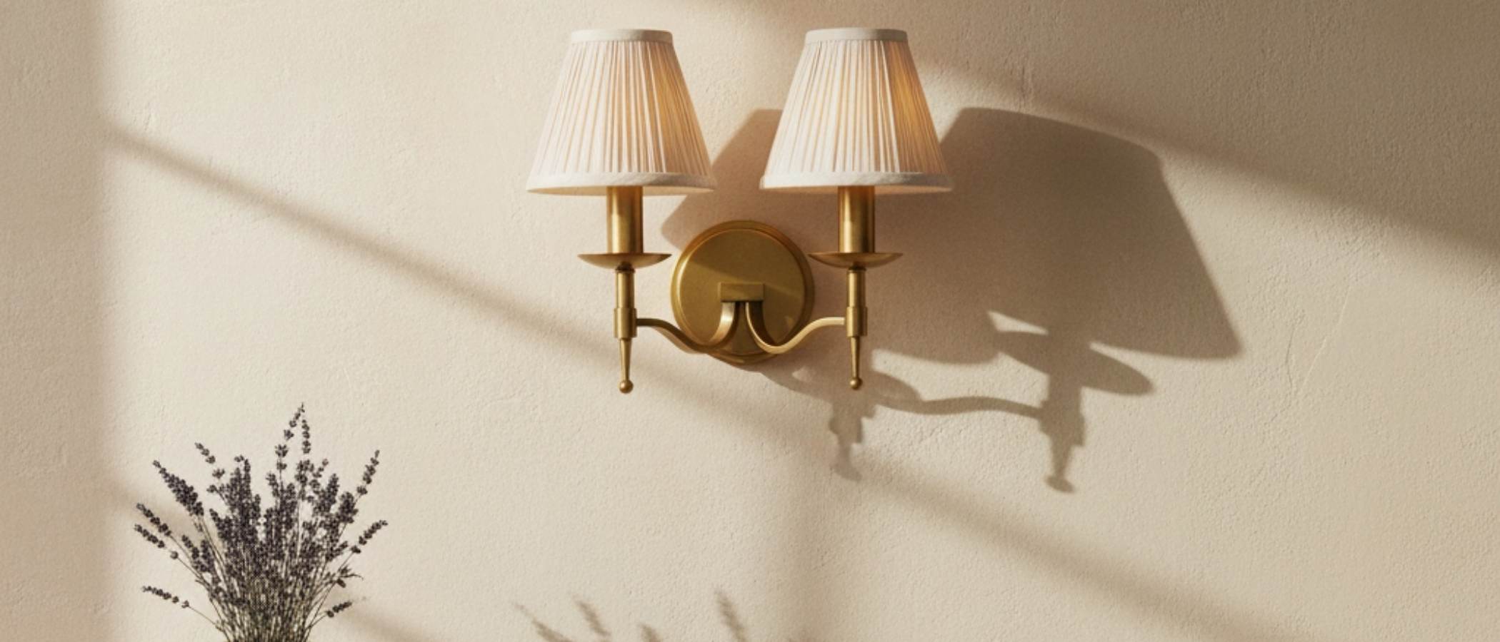 Tela brass wall light with fabric shades casting soft shadows