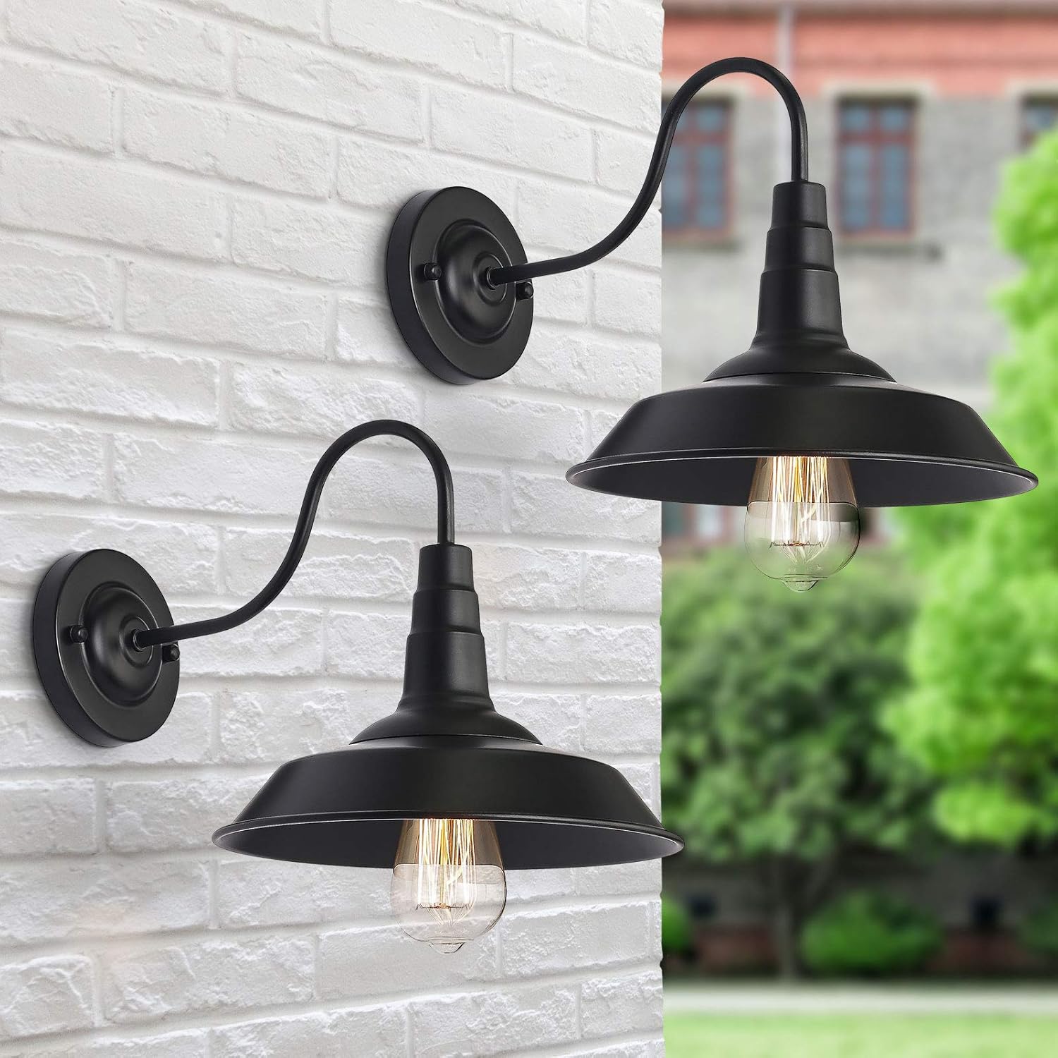 Two black outdoor wall lights mounted on a white brick exterior wall