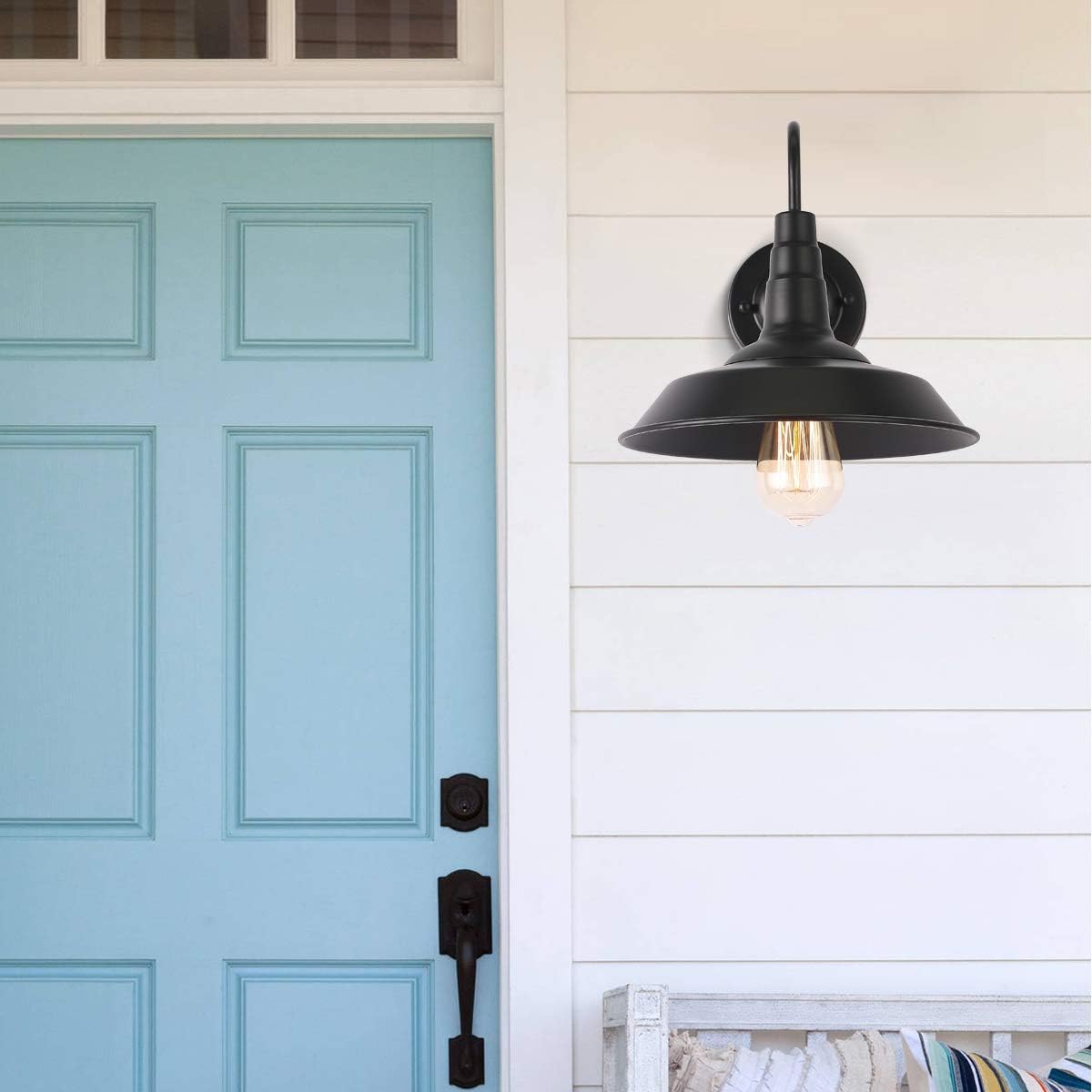 Outdoor gooseneck wall sconce beside a blue front door