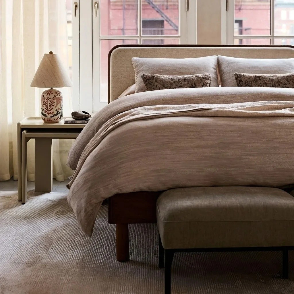 Ceruna table lamp beside a layered bed