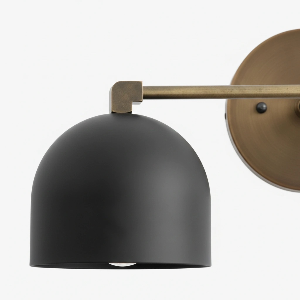 Close view of black dome shade and brass arm