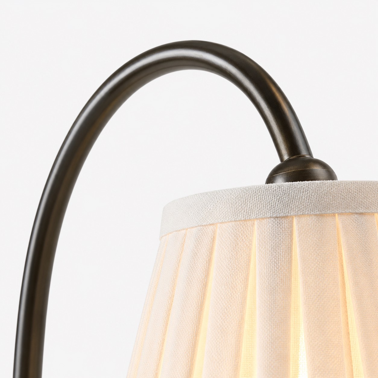 Close view of the curved metal lamp arm and shade