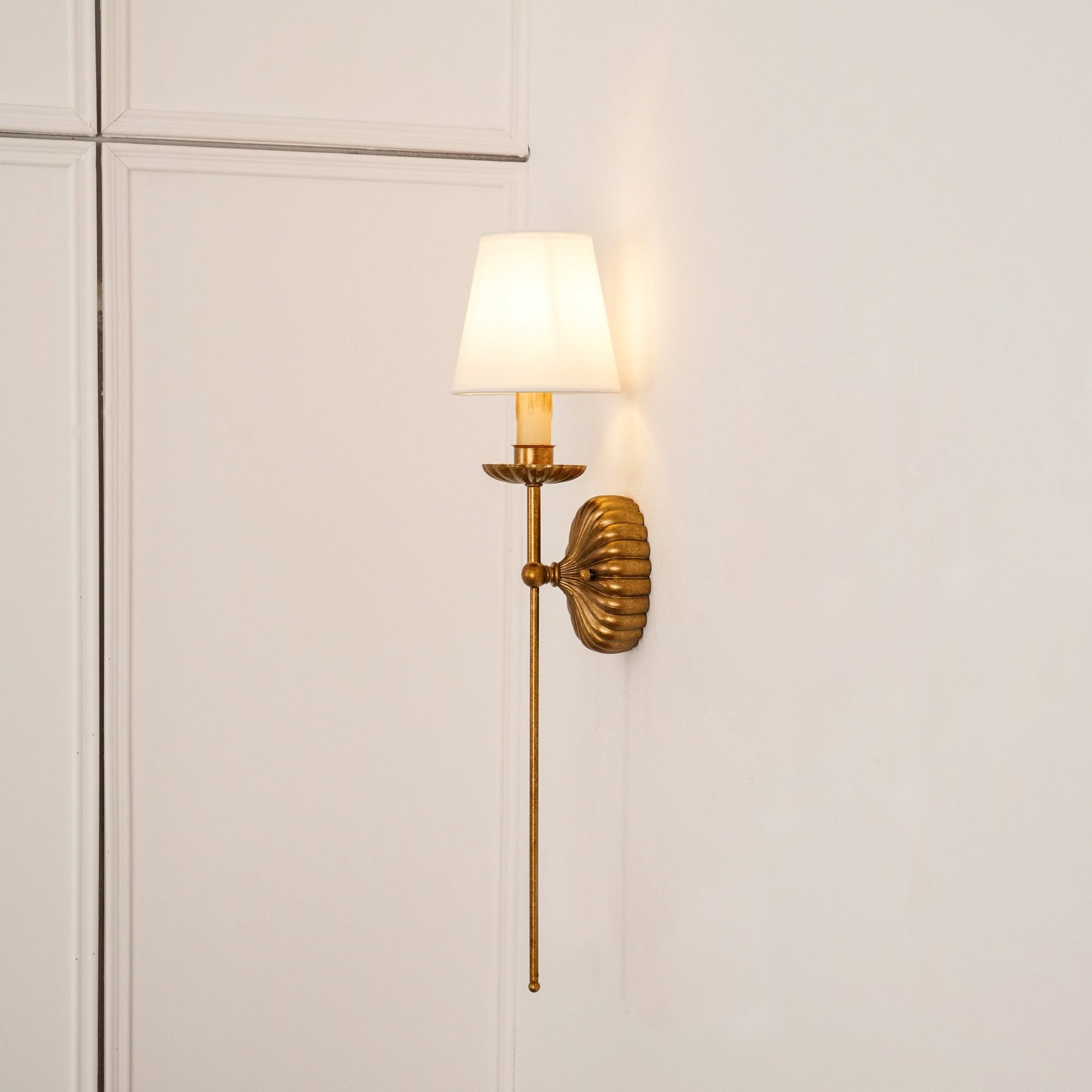Catina wall sconce shown on a paneled wall