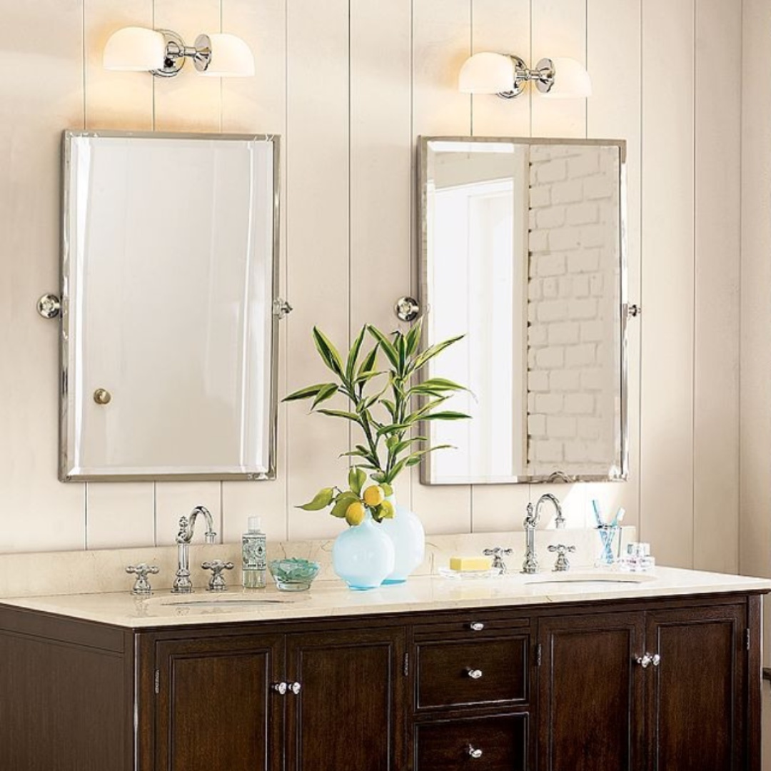Double horizontal wall sconce installed above twin bathroom mirrors