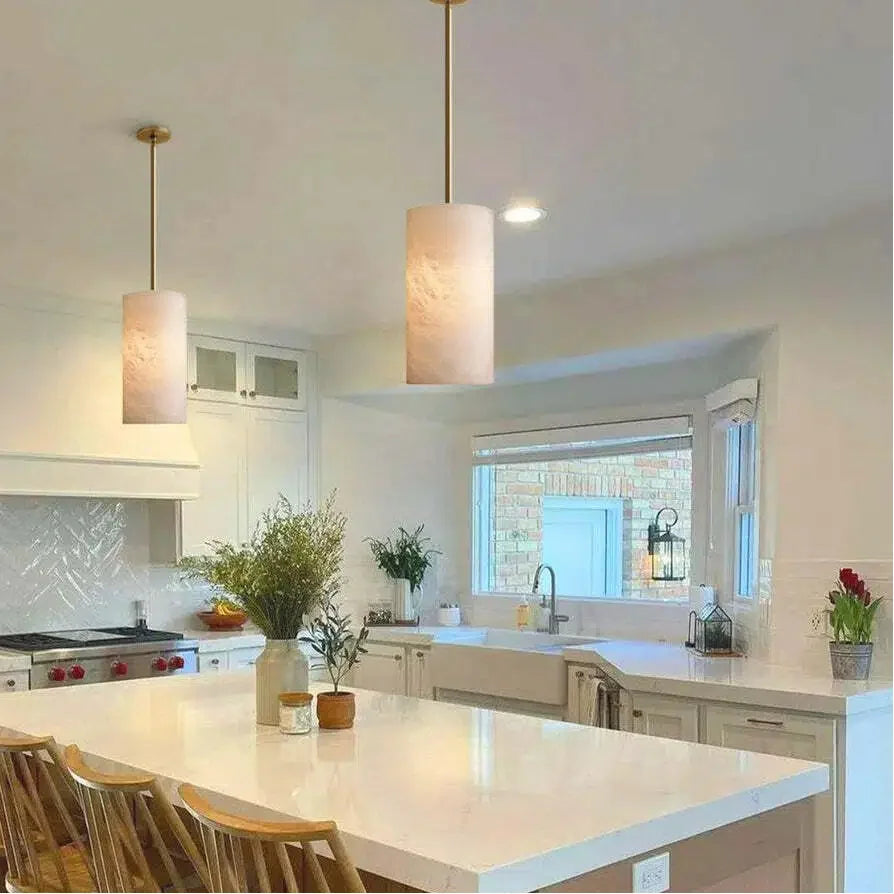 Alabaster cylinder pendant lights over a kitchen island