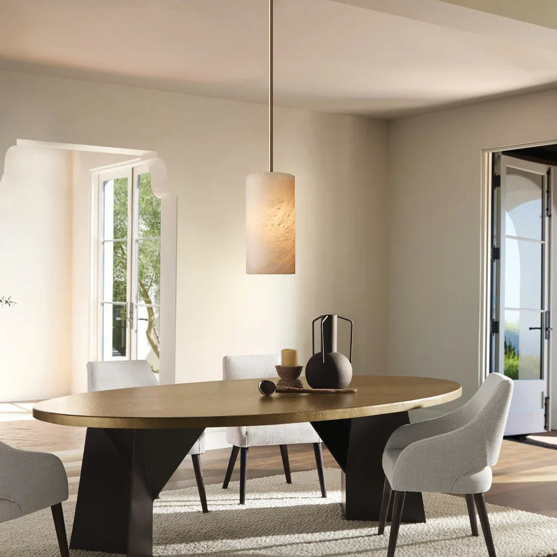 Hand carved alabaster cylinder pendant light above a dining table