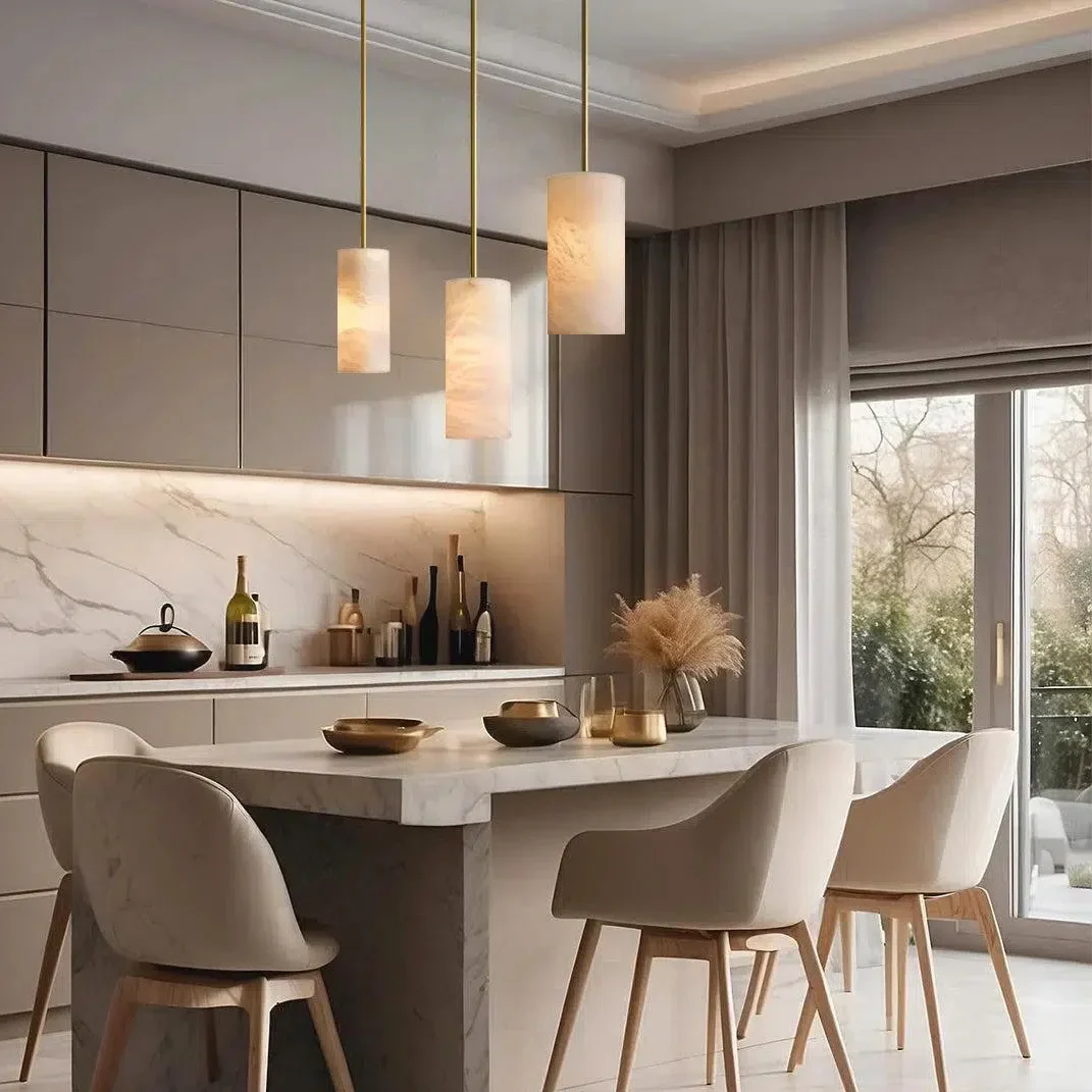 Alabaster cylinder pendant lights above a dining table